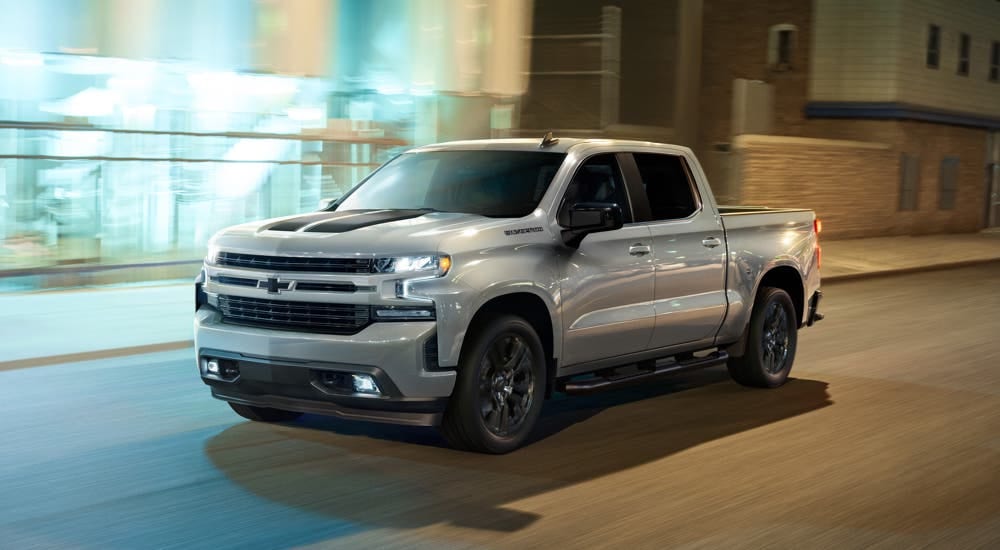 A grey 2020 Chevy Silverado 1500 Rally Edition is shown driving on a city street.