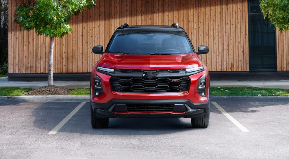 A red 2025 Chevy Equinox RS for sale parked in an empty lot.