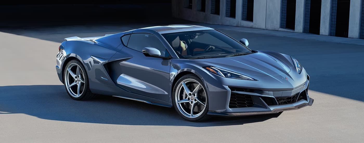 A grey 2024 Chevy Corvette E-Ray parked in an empty lot.