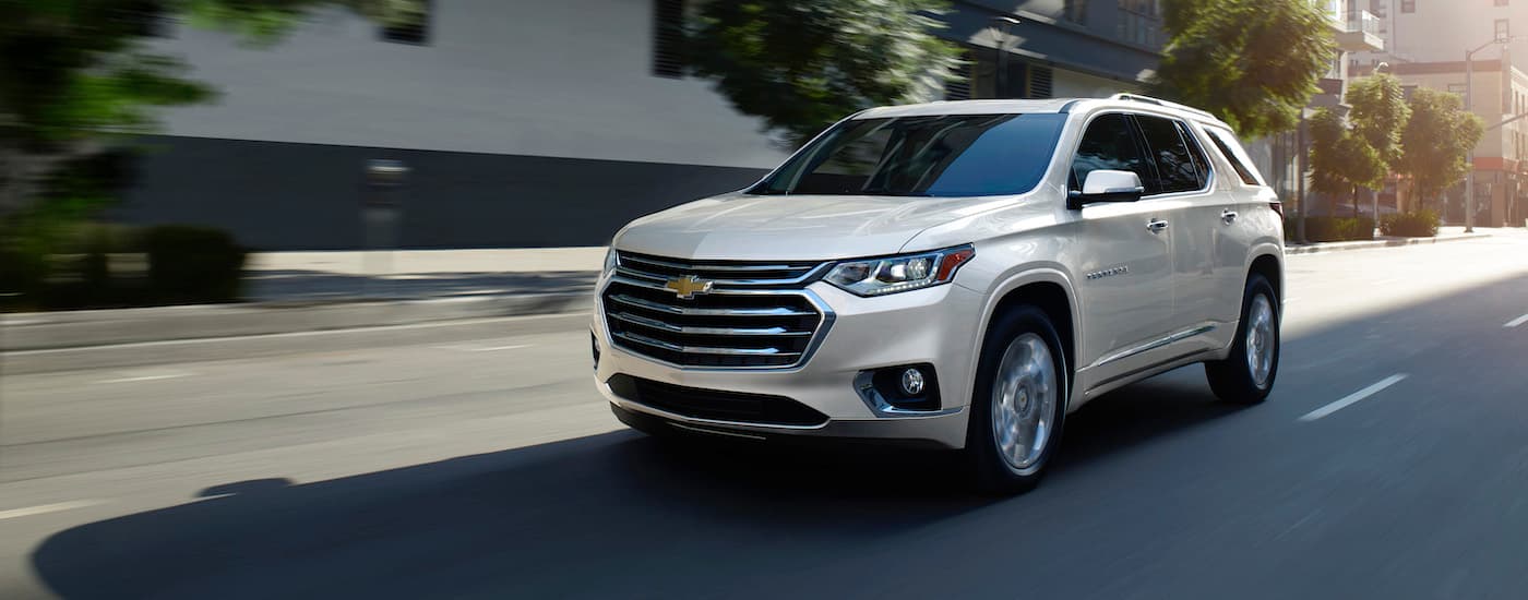 A white 2019 Chevy Traverse driving on a city street.