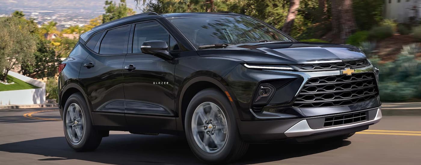 A black 2023 Chevy Blazer driving on a winding road.