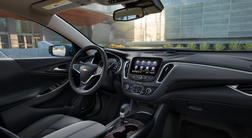 The black interior of a 2024 Chevy Malibu is shown from the passenger seat.