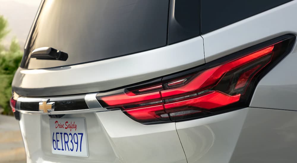 Close-up of the rear lift gate and brake lights on a silver 2023 Chevy Traverse.