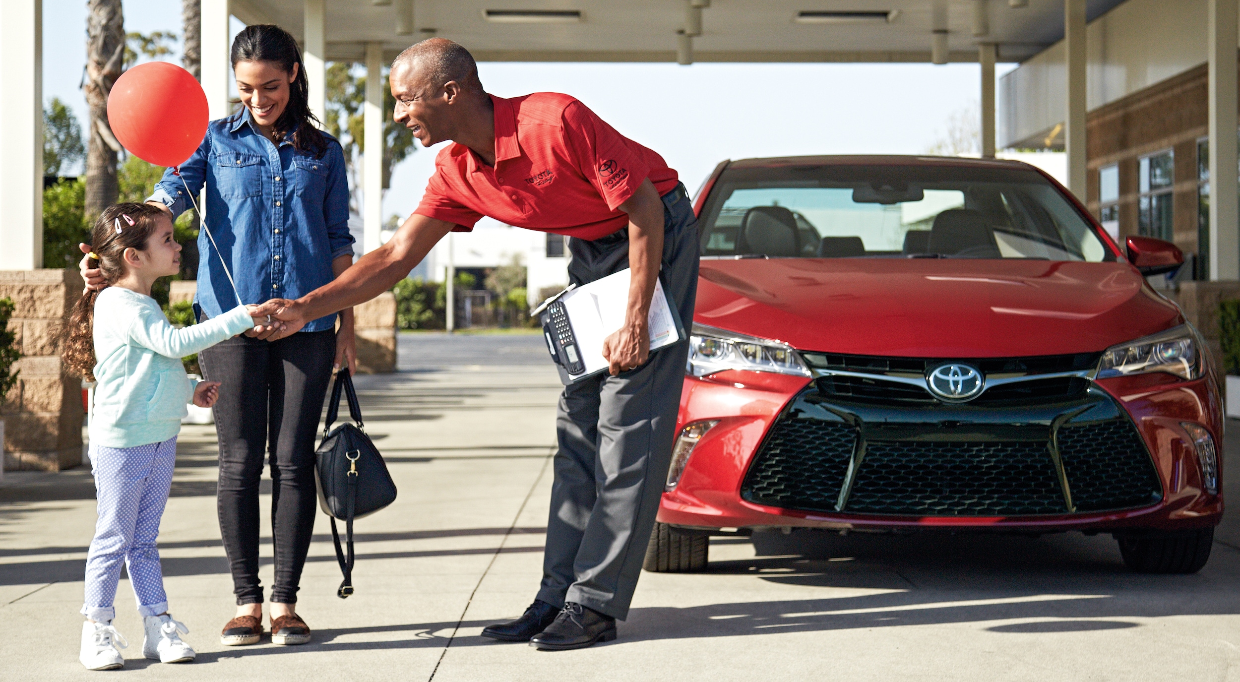 Toyota service employee shaking hands with child