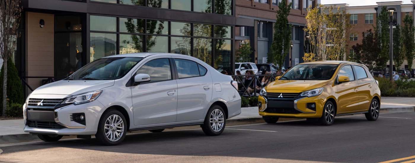 A silver 2024 Mitsubishi Mirage G4 and a yellow 2024 Mitsibishi Mirage are shown parallel parked.