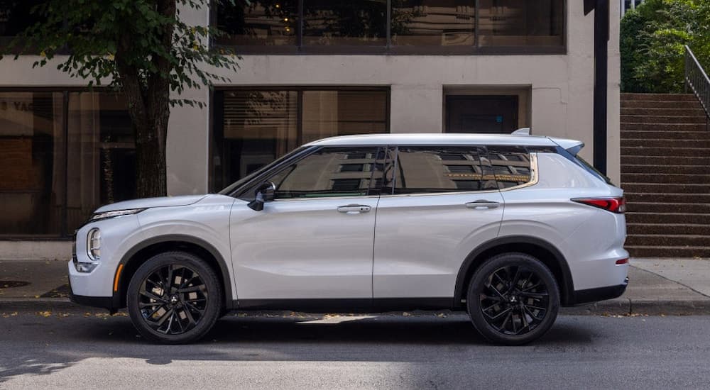 A white 2023 Mitsubishi Outlander parked on a trendy city street