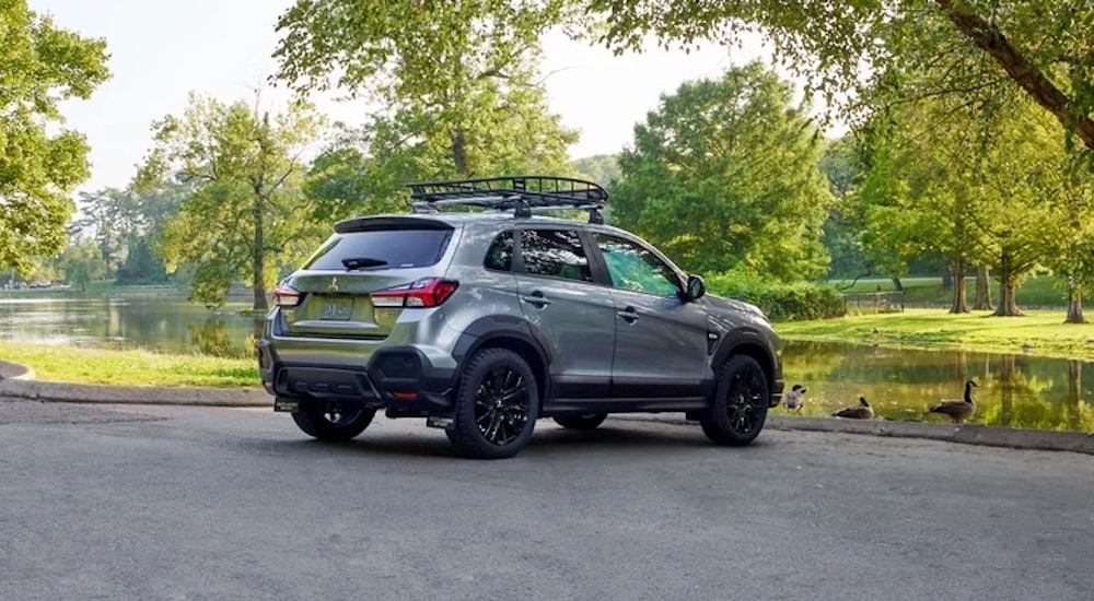 A grey 2024 Mitsubishi Outlander Sport is shown from the rear at an angle.