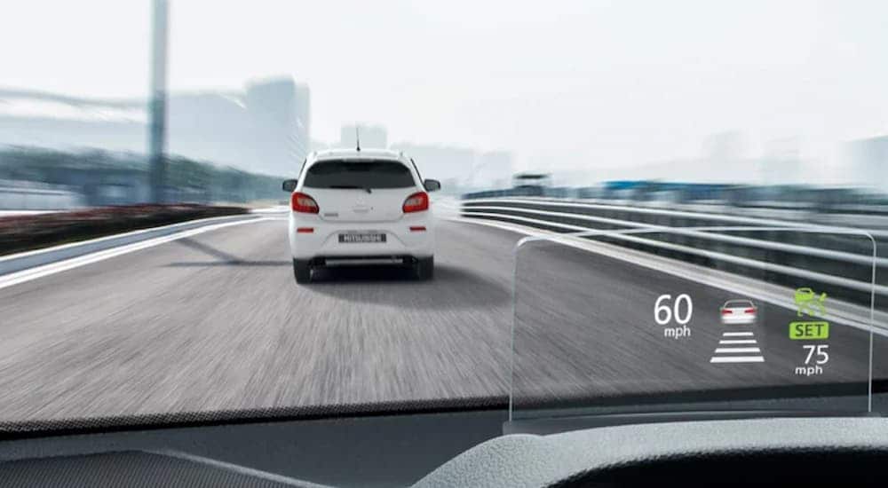 The heads up display in a 2024 Mitsubishi Eclipse Cross is shown while driving on a highway.