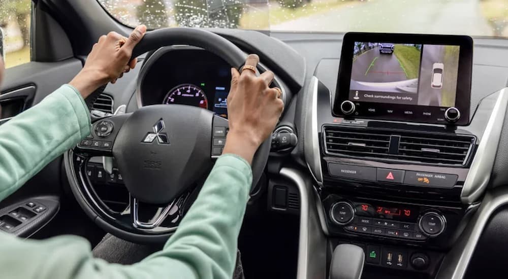 A woman is using the backup camera in a 2024 Mitsubishi Eclipse Cross.