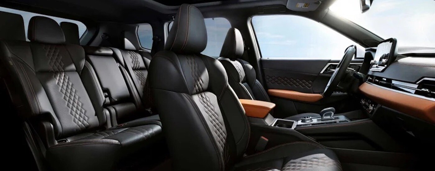 The black interior of a 2024 Mitsubishi Outlander is shown from the passenger side.