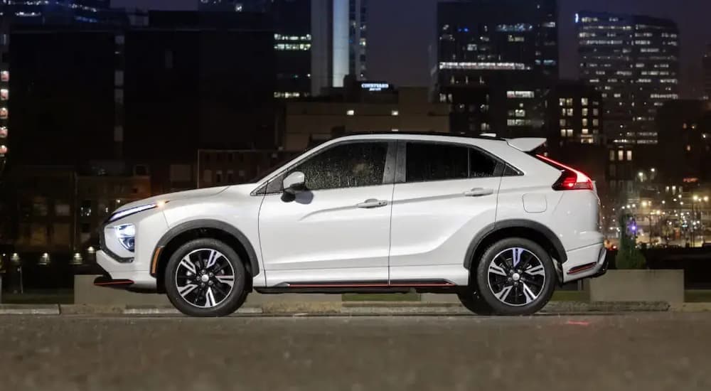 A white 2024 Mitsubishi Eclipse Cross parked in a city at night.