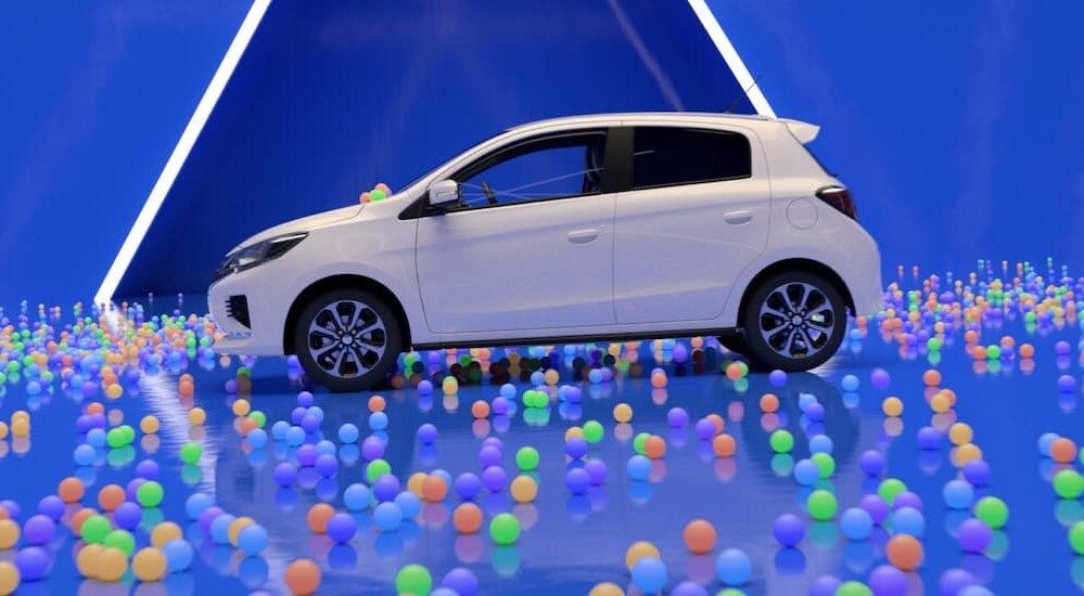 A white 2024 Mitsubishi Mirage is parked near colorful balls.