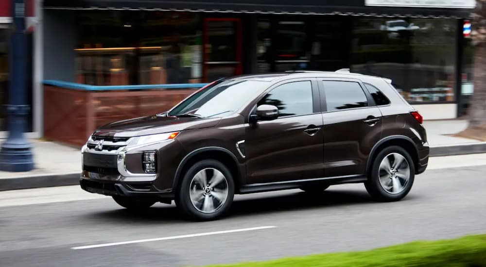 A black 2021 Mitsubishi Outlander Sport driving on a city street.