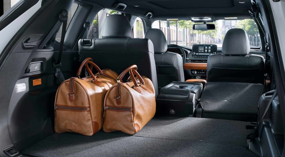 The black interior of a 2023 Mitsubishi Outlander PHEV shows the rear cargo storage area.