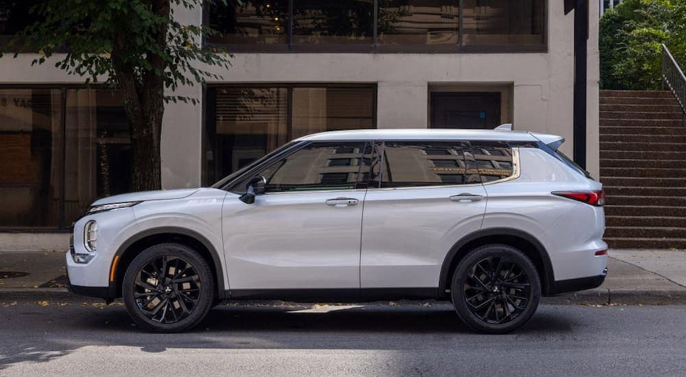 A white 2023 Mitsubishi Outlander parked on a city street.