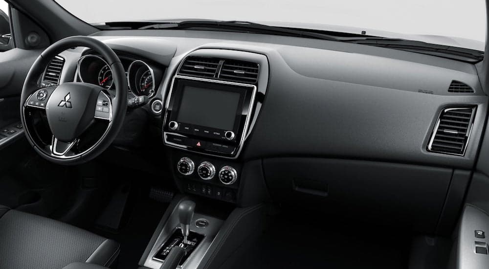 The black interior of a 2023 Mitsubishi Outlander Sport as seen from the passenger seat.