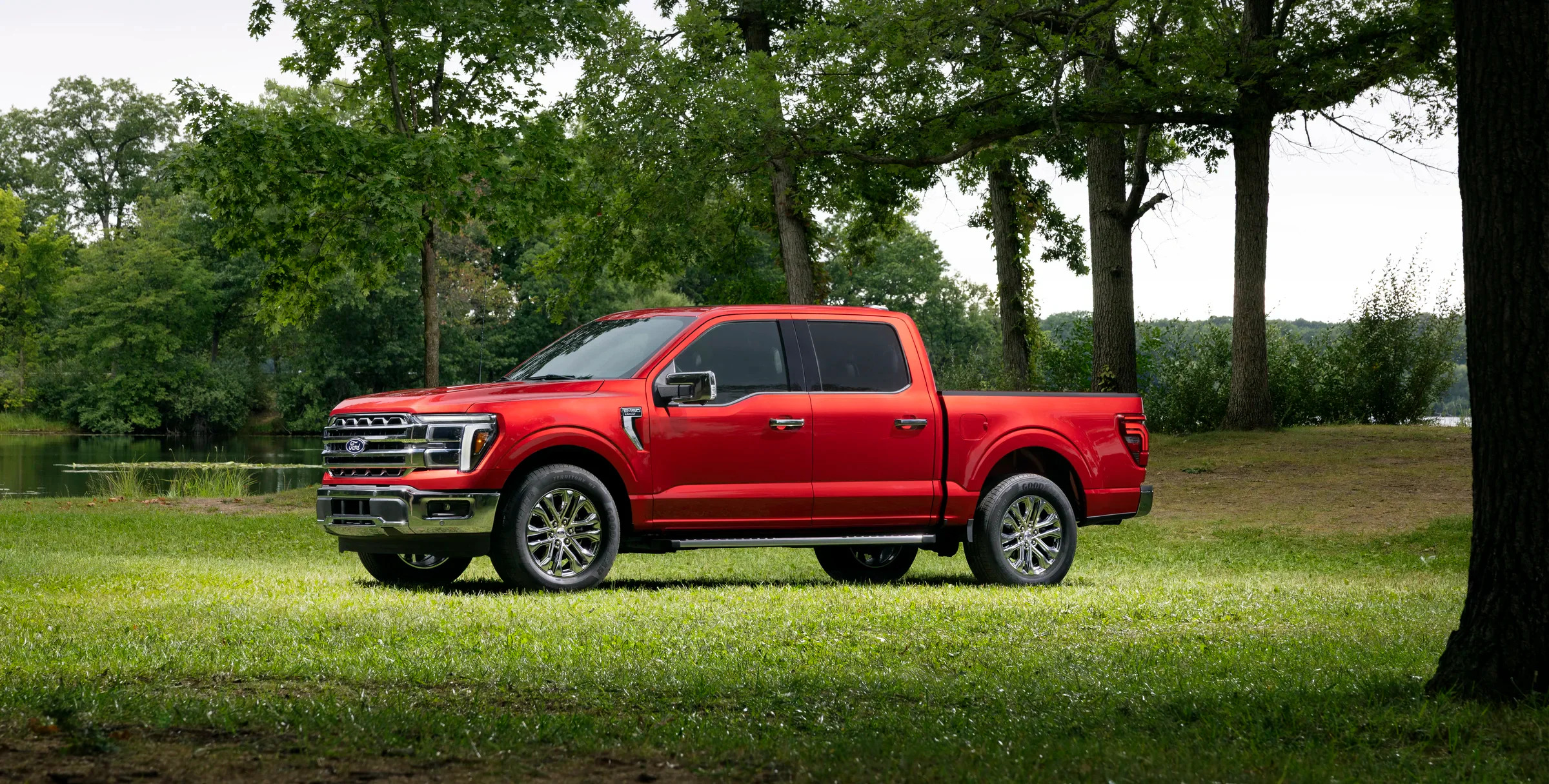 A red Ford F-150 parked in the middle of a grassy field.