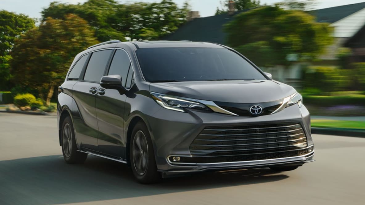 A gray Toyota Sienna driving through a suburban neighborhood.