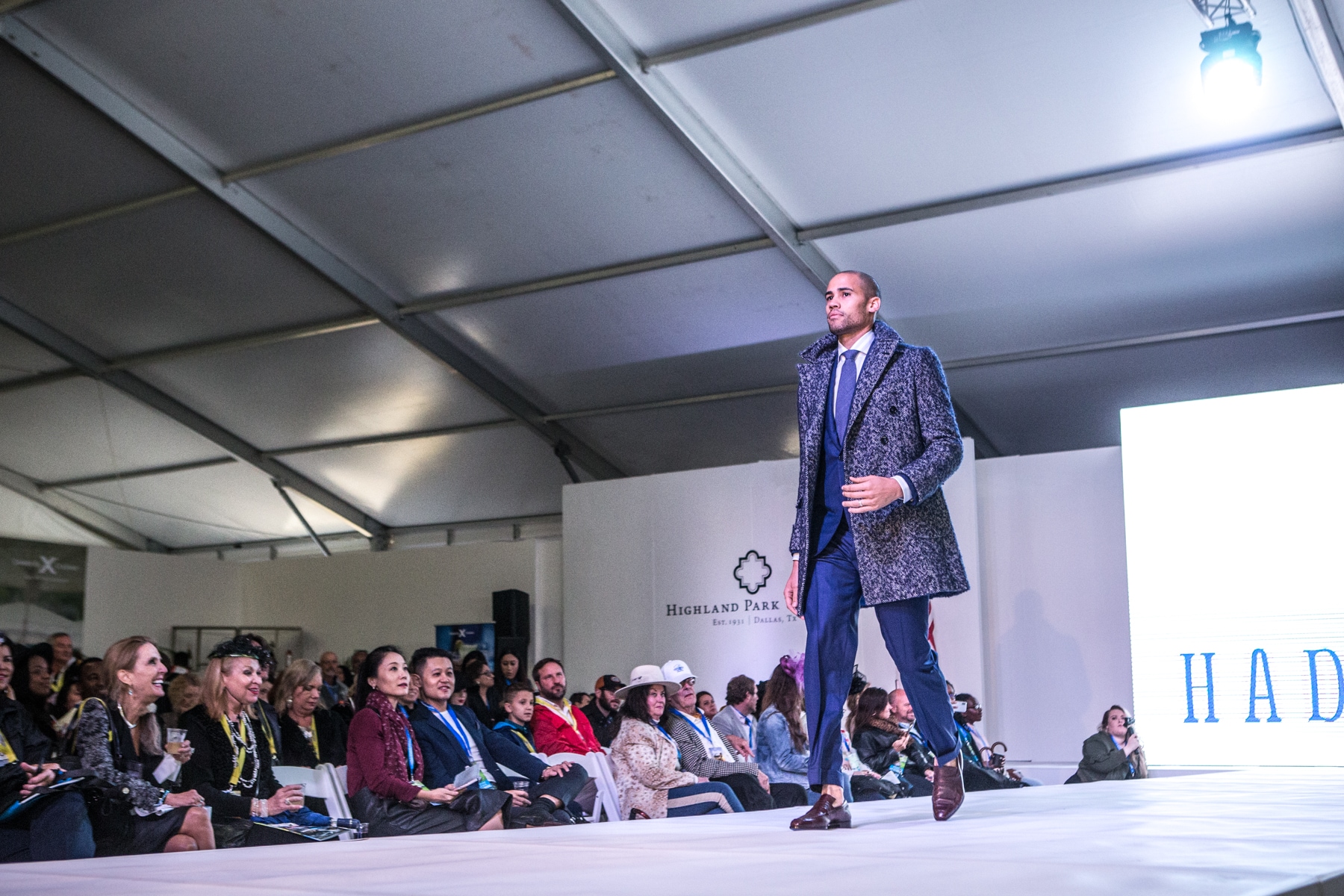 A male model walk down the catwalk in formal attire at the Luxury Supercar Showcase in Dallas