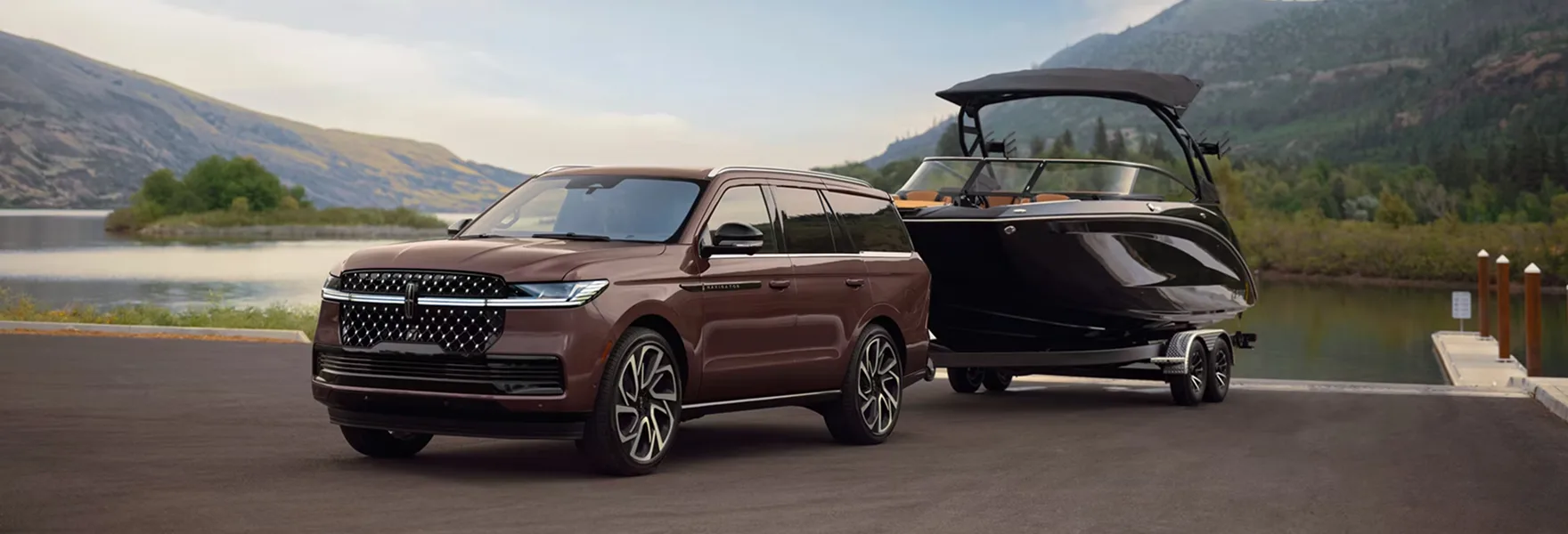 2027 Lincoln Navigator towing a boat by a lake