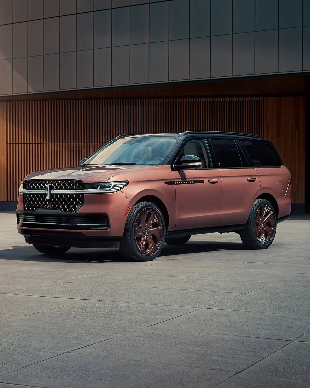 2026 Lincoln Navigator Black Label in a copper finish, three-quarter front view, parked outside a modern building