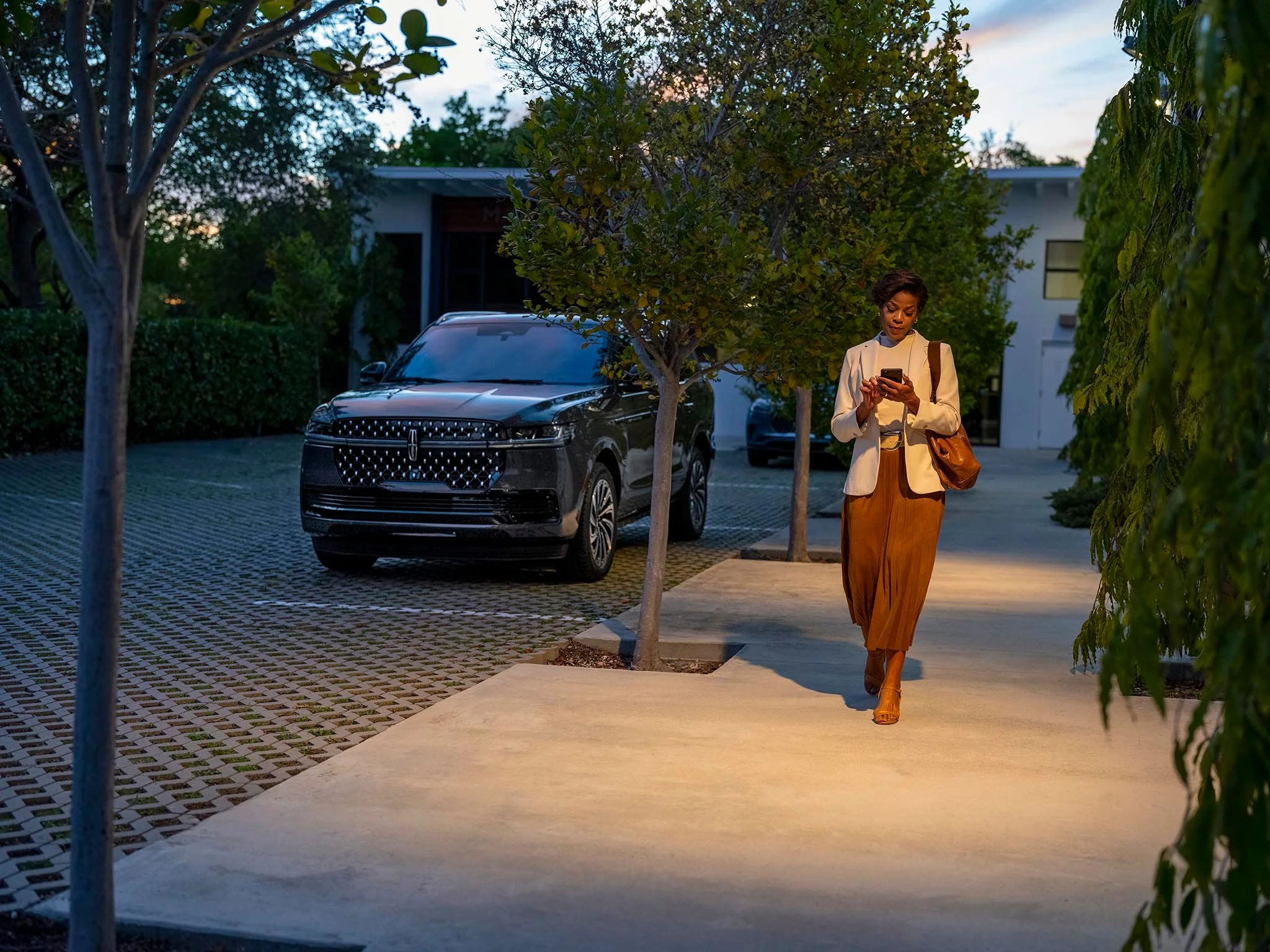 A Lincoln Navigator parked outside a home at dusk