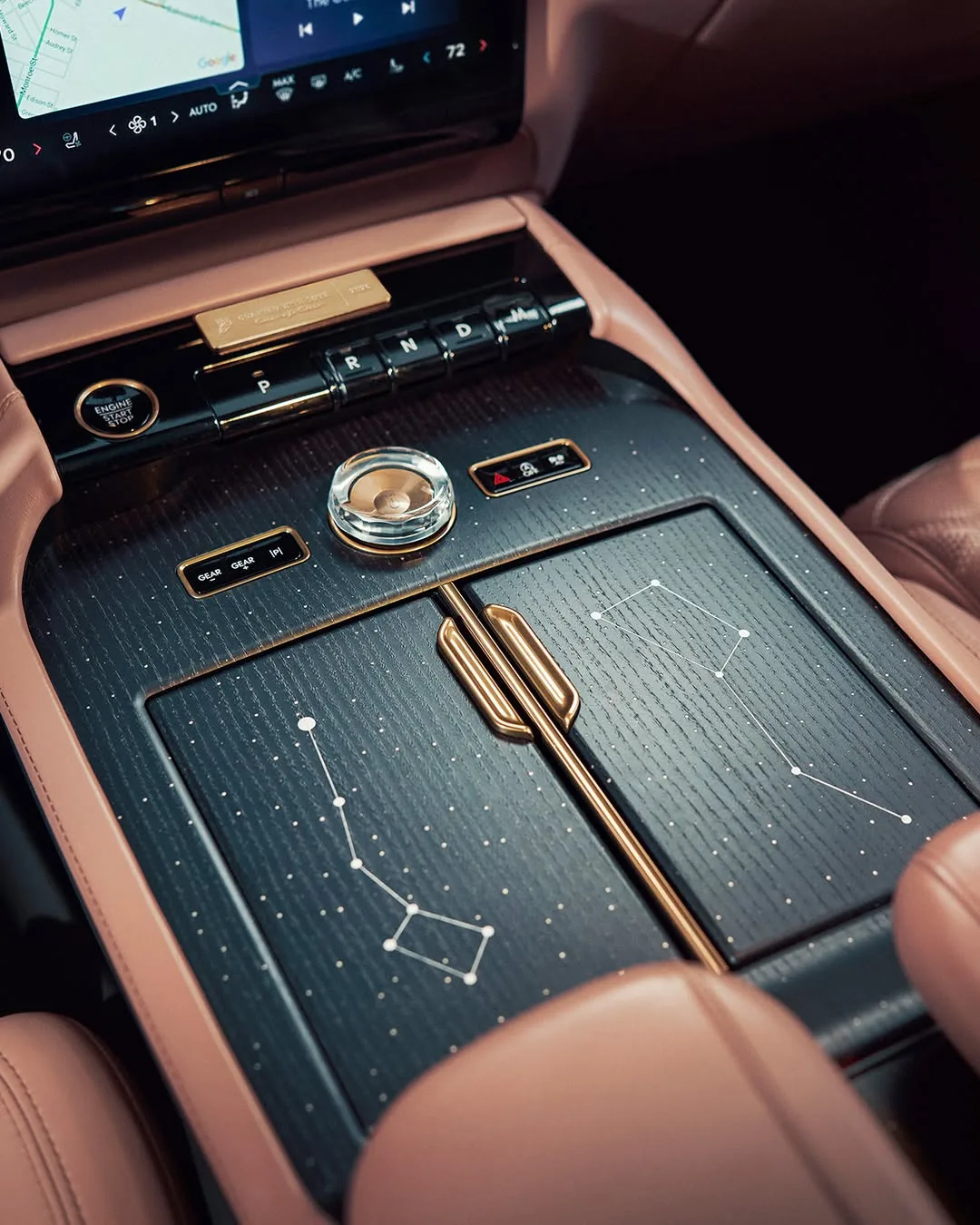 Center console of the Navigator Black Label with a star-constellation inlay in dark wood, gold accents, and crystal controls