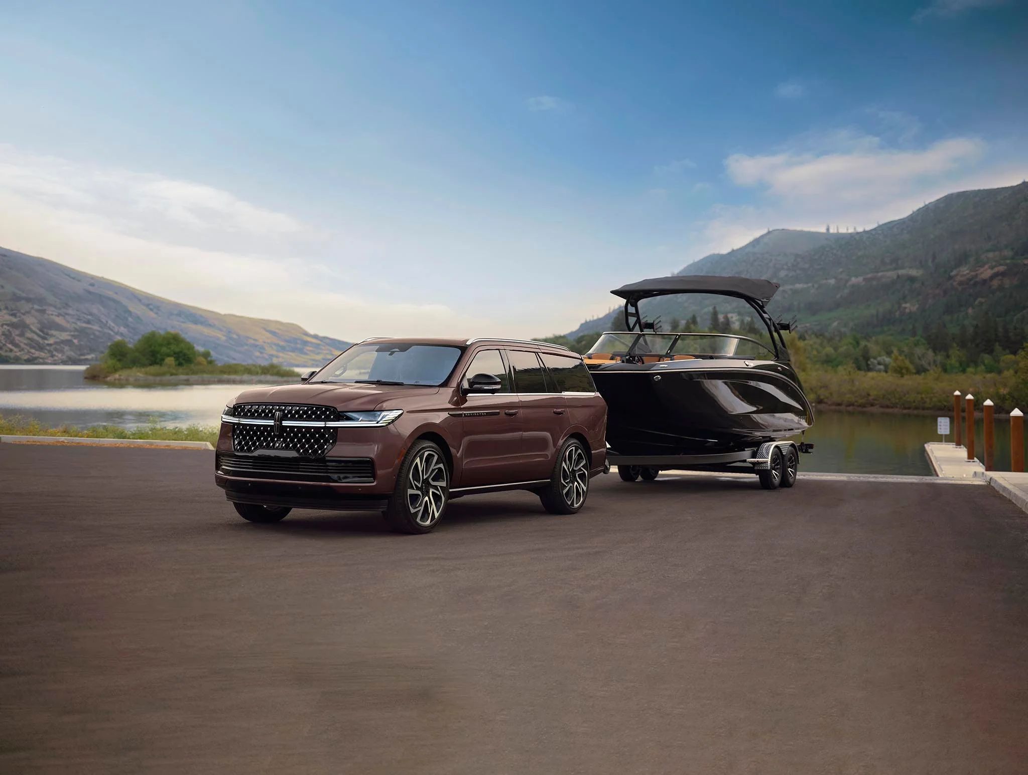 A Lincoln Navigator towing a boat on a lakeside road
