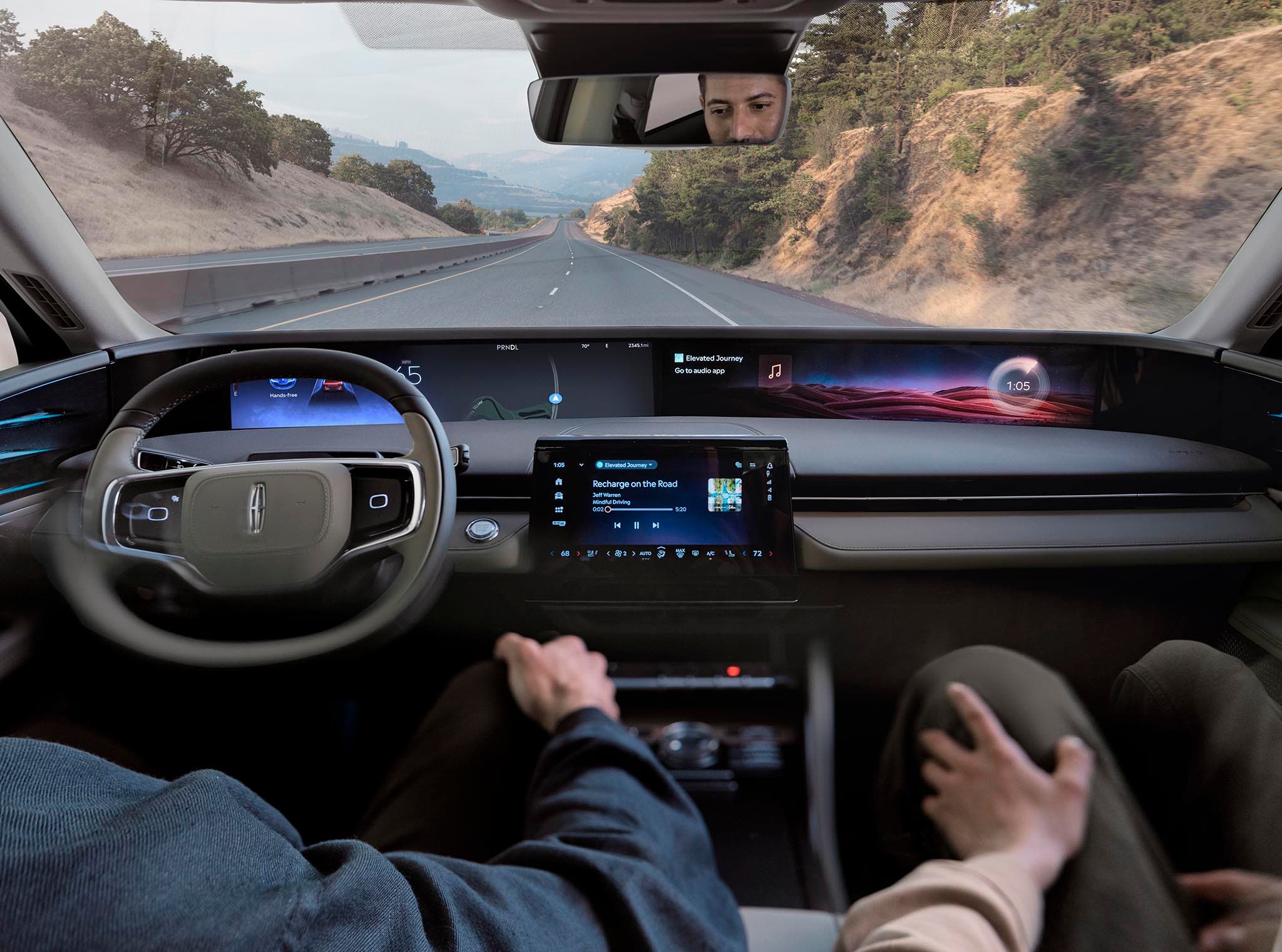 The panoramic display of a Lincoln Nautilus seen from the driver's seat, hands resting on the wheel