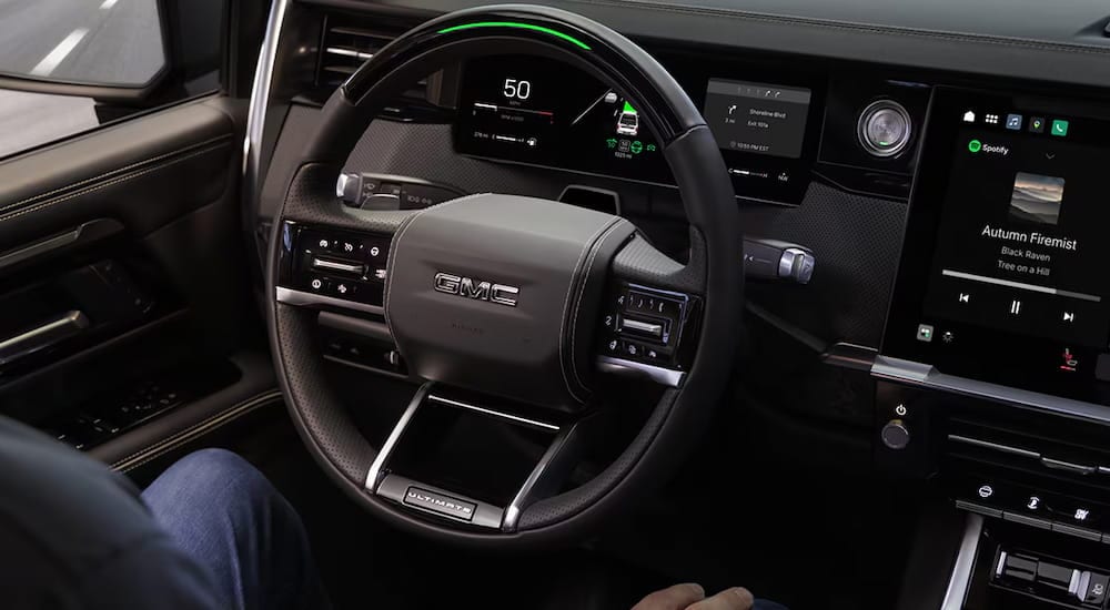 The wheel and dashboard in the interior of a 2027 GMC Sierra 1500.