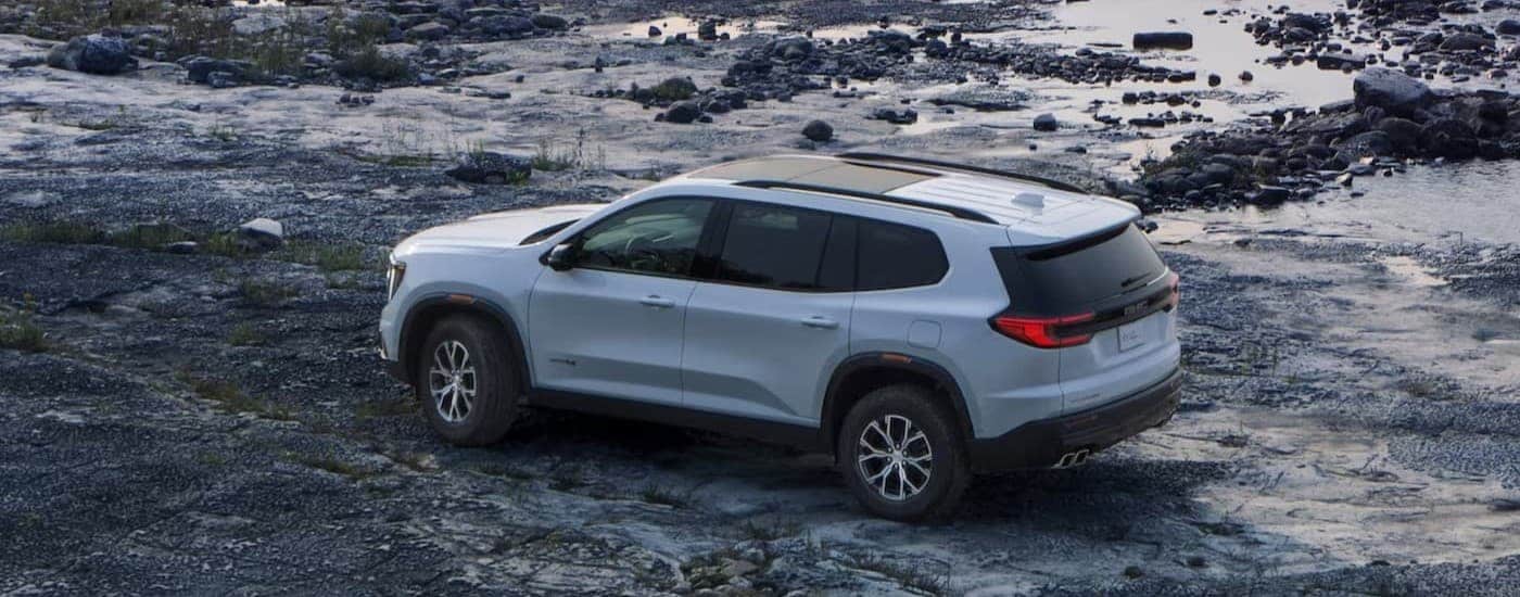 A white 2024 GMC Acadia AT4 parked offroad.