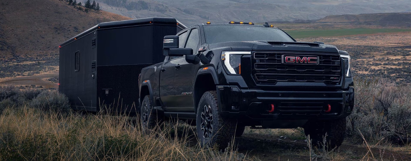 Black 2026 GMC Sierra 2500 HD towing a trailer