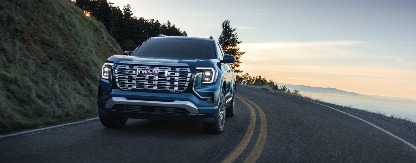 Blue 2026 GMC Terrain driving on a winding road