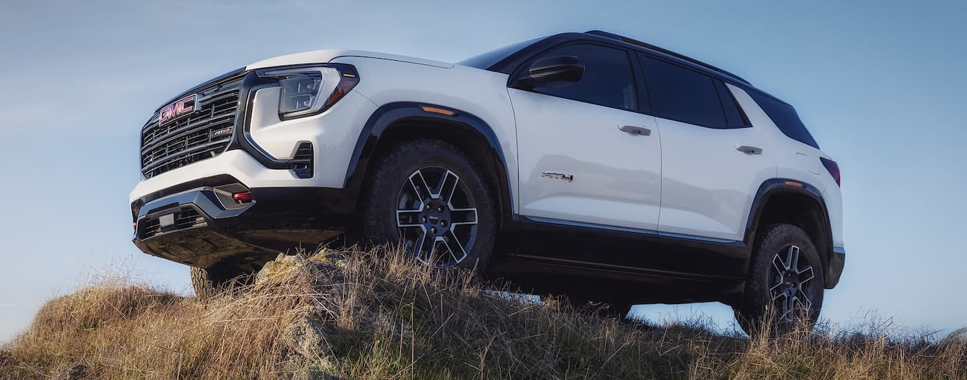 Low angle view of a white 2026 GMC Terrain parked off-road.
