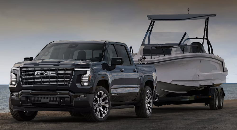 Black 2027 GMC Sierra 1500 towing a white boat.