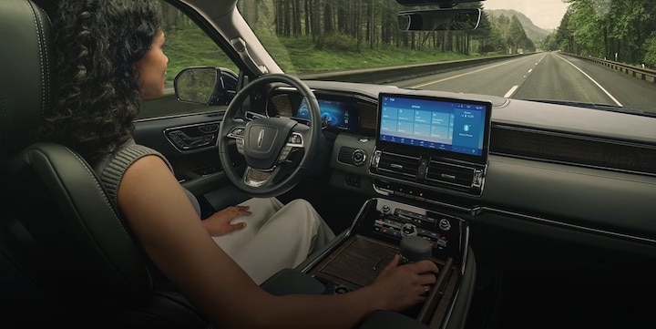 A woman using lincoln bluecruise to drive her lincoln down the road