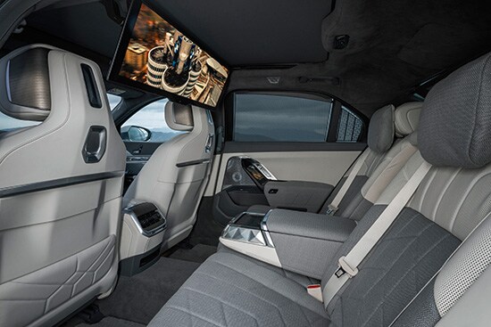 Luxurious backseat of the BMW i7, featuring plush seating, advanced technology, and a spacious, elegant interior for ultimate comfort.