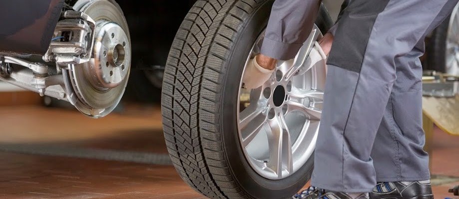 Mechanic Putting Tire on Car