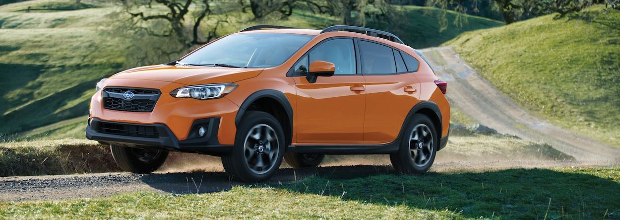 orange subaru on a hill