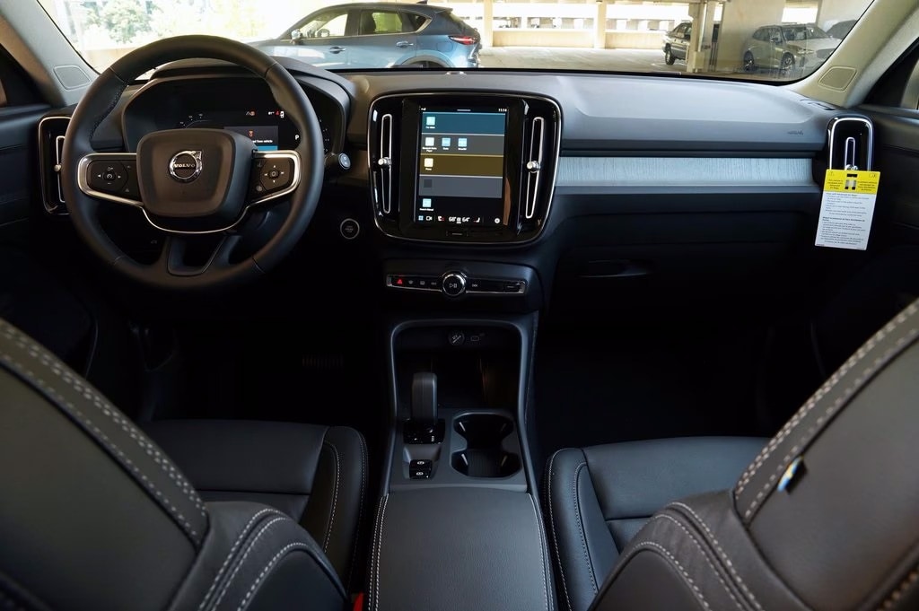 Illustration of the 2025 Volvo XC40 showcasing its advanced safety features, including collision avoidance, lane-keeping assist, and adaptive cruise control in action.