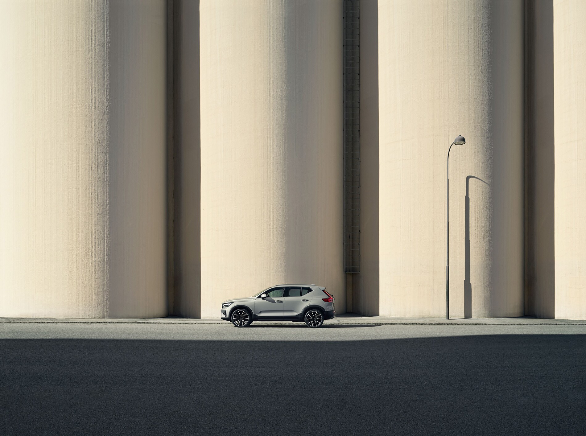 Front view of the 2025 Volvo XC40 parked in an urban setting, showcasing its modern Scandinavian design, bold grille, and signature Thor's Hammer LED headlights.