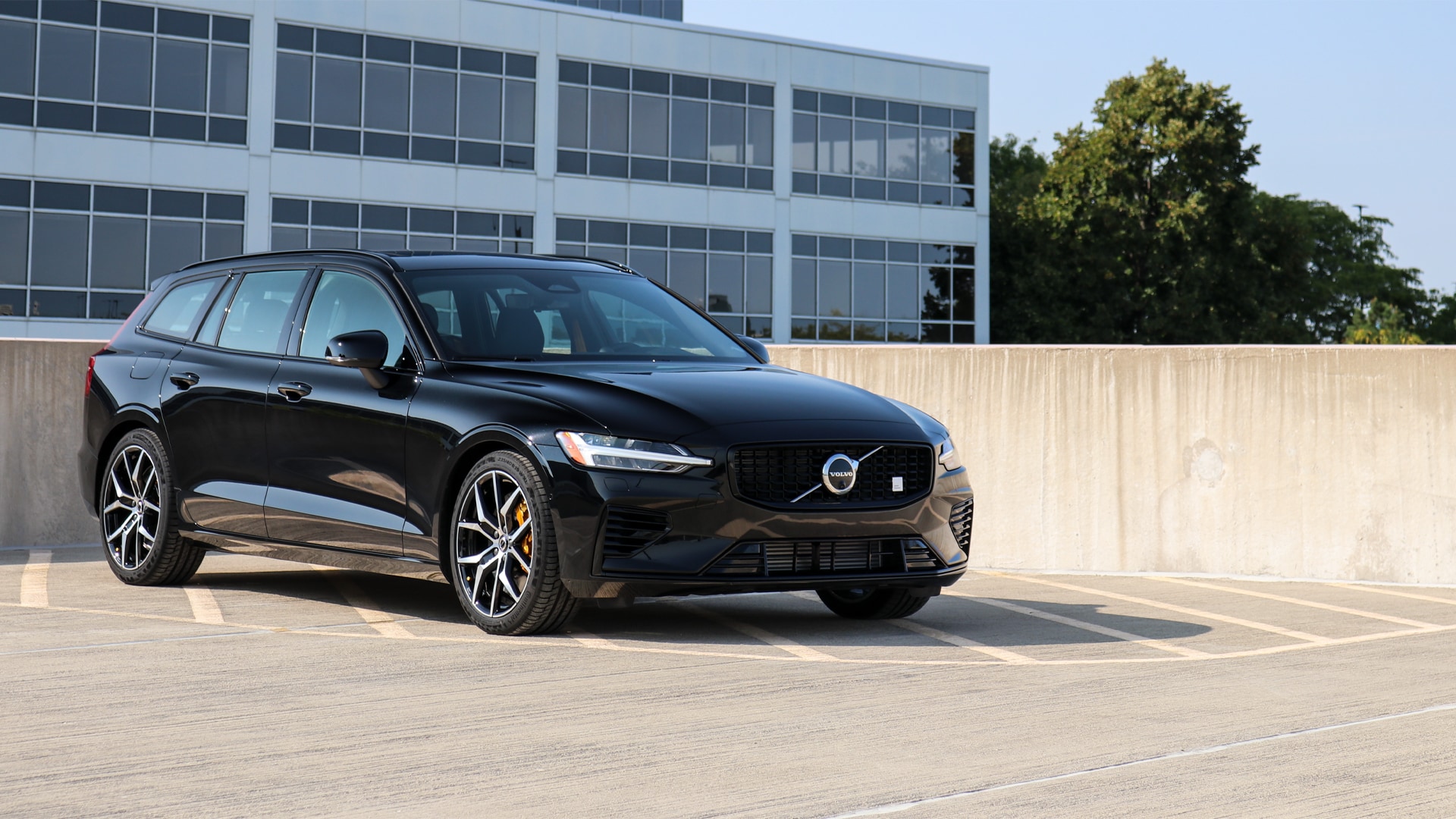 Front view of the 2025 Volvo V60 Cross Country parked in a scenic outdoor setting, showcasing its rugged design, elevated ground clearance, and signature Thor's Hammer LED headlights.