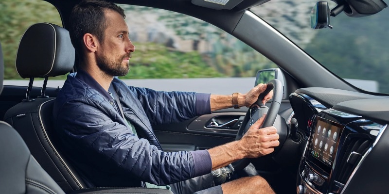 A Man Driving a Chevrolet with Hands on the Steering Wheel in Sturgeon Bay