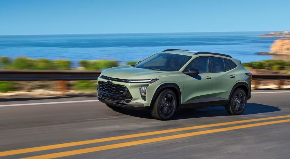 A green 2026 Chevy Trax ACTIV driving on a highway.