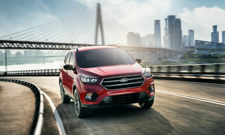 Red 2019 Ford Escape driving on highway next to bridge