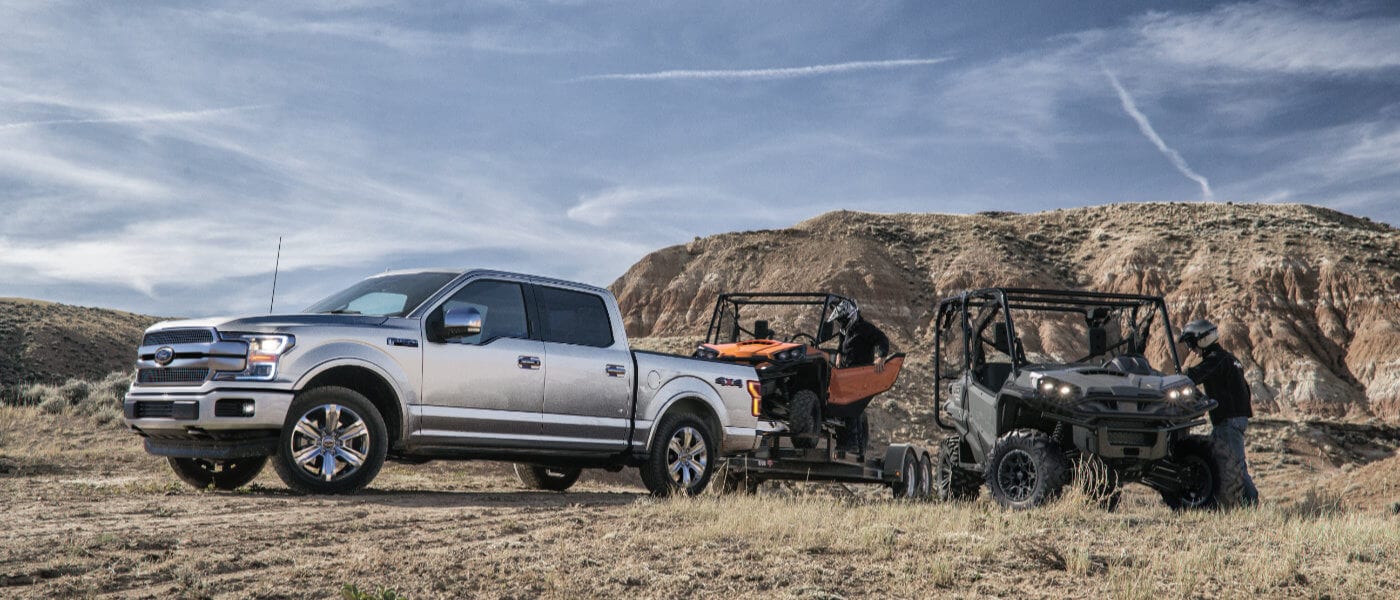 2019 Ford F-150 towing ATVs in field