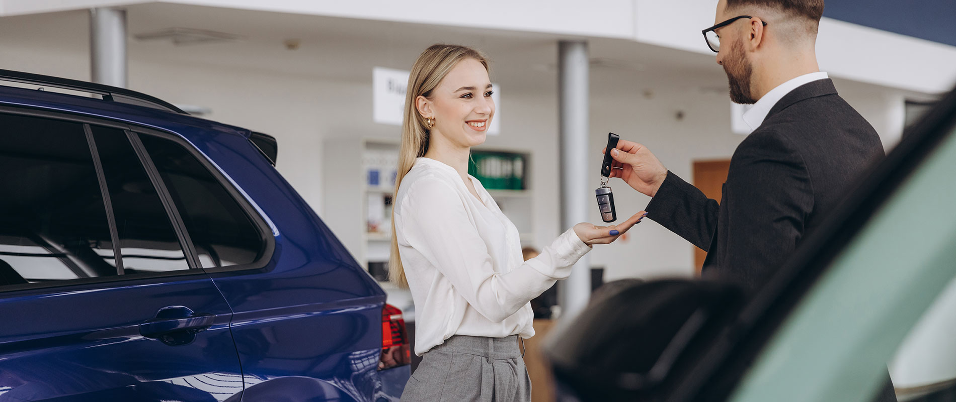 Joyful young woman gets the keys to her new Ford