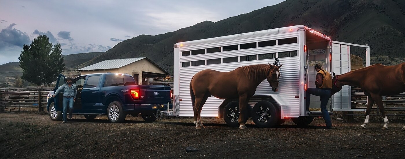 Blue 2026 Ford F-150 King Ranch towing a horse trailer
