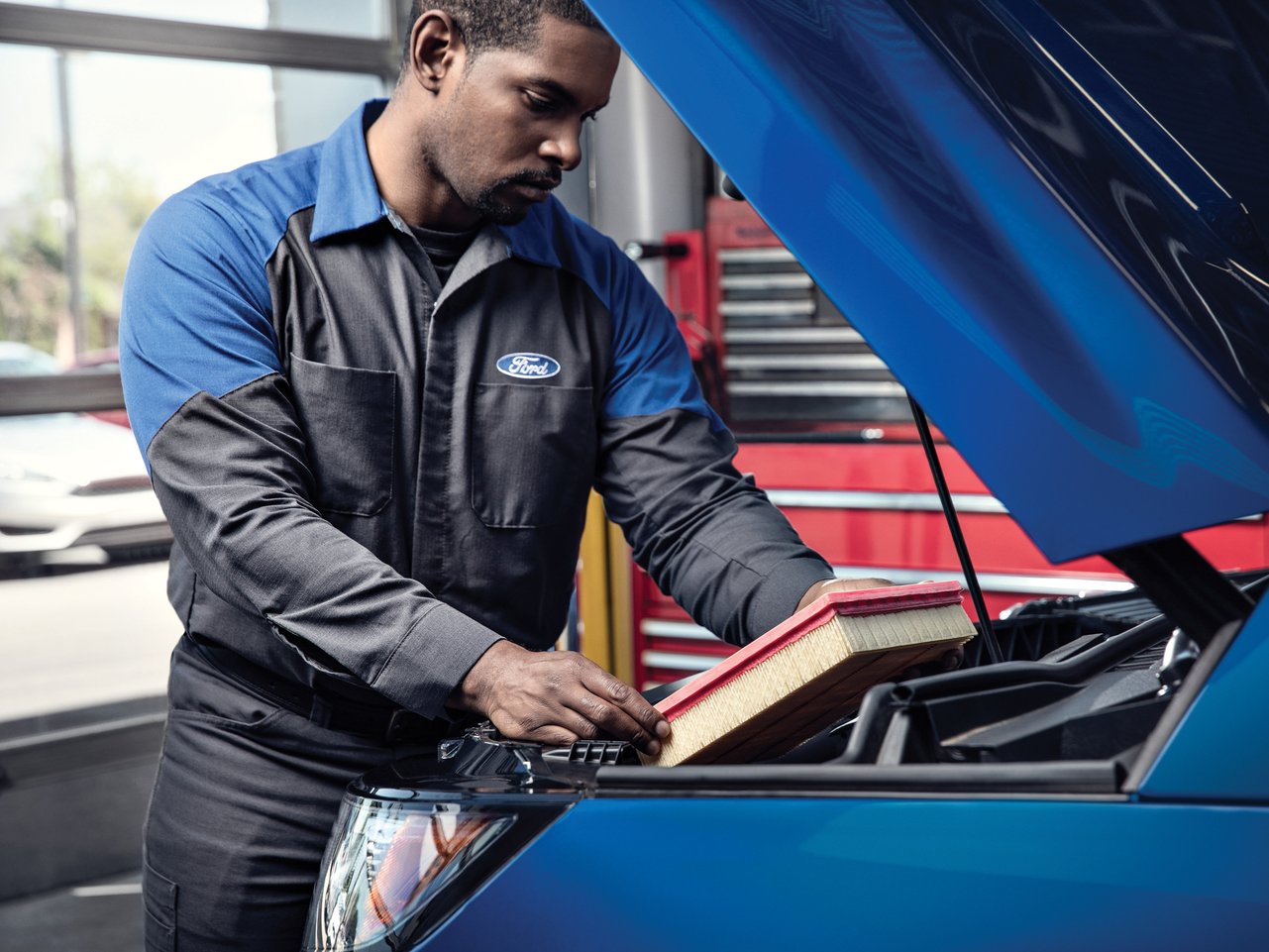 Ford service staff changing the air filter of a Ford vehicle