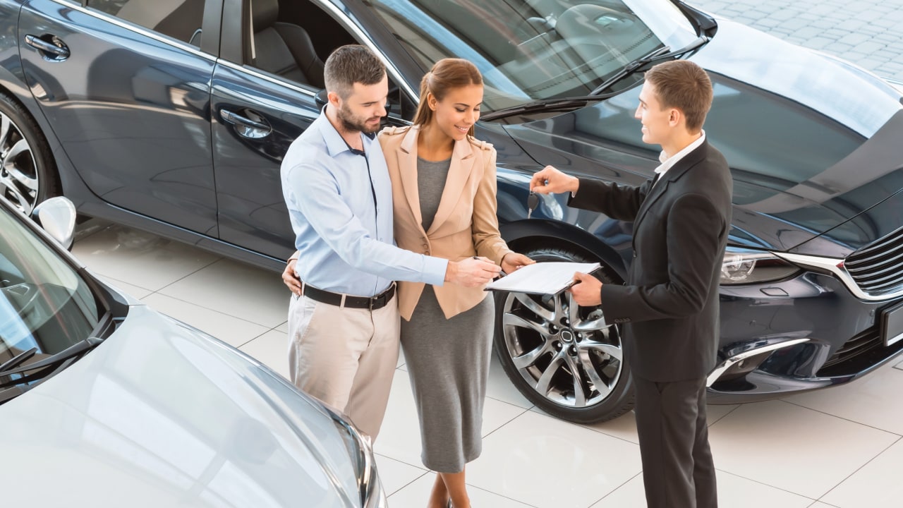 Couple purchasing Subaru with salesperson